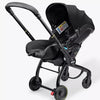 Black baby stroller with car seat attachment on a white background